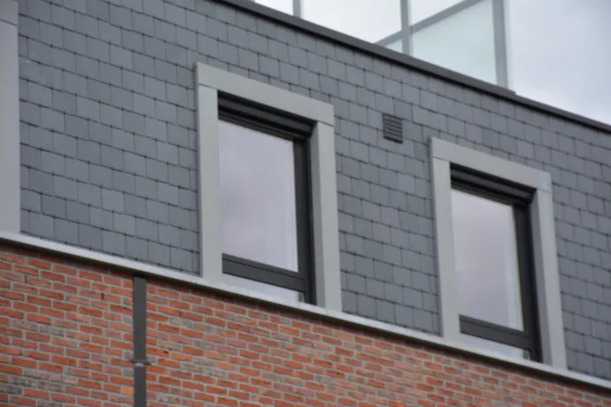 Gevelbekleding natuurleien afgewerkt met quartz zink